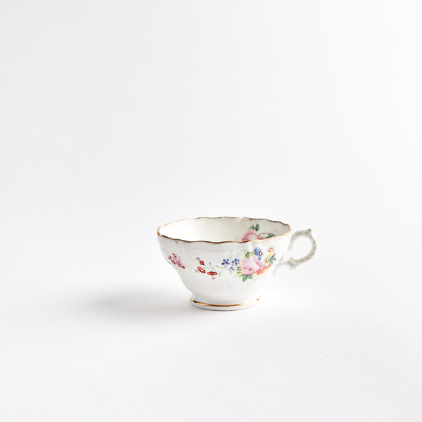 White teacup with multicolour flowers.
