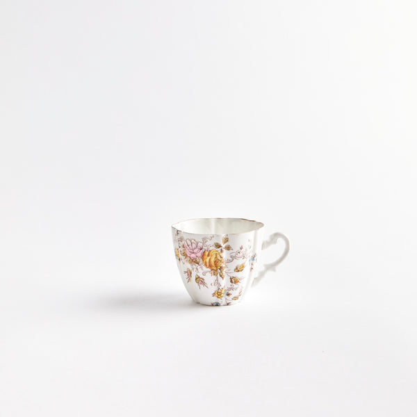 White teacup with pink and yellow flowers.