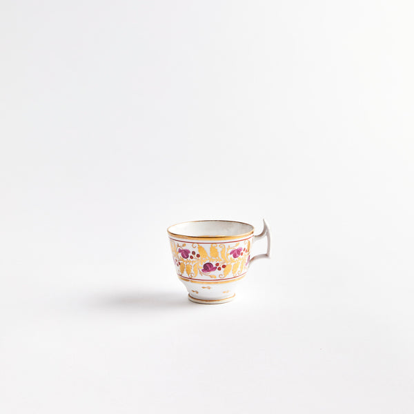 White teacup with gold and purple flowers.