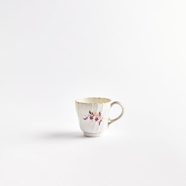 White teacup with gold and purple flowers.