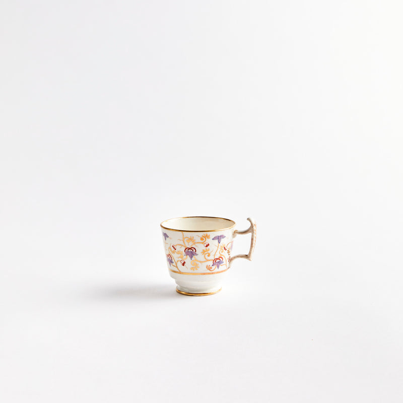 White teacup with purple flowers and gold detail.