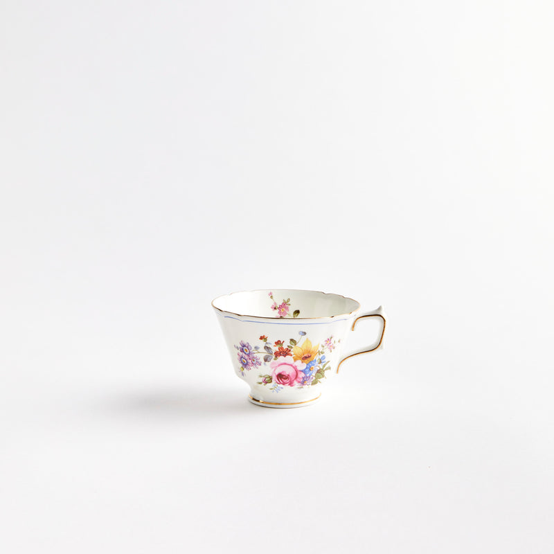 White teacup with multicolour flowers and gold detail.