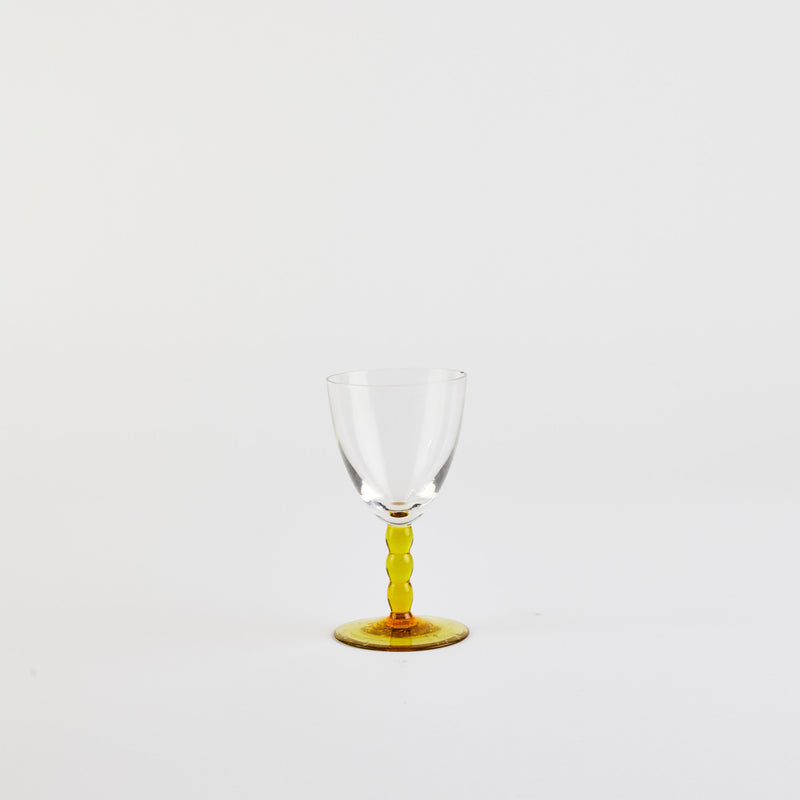 Wine glass with yellow stem.