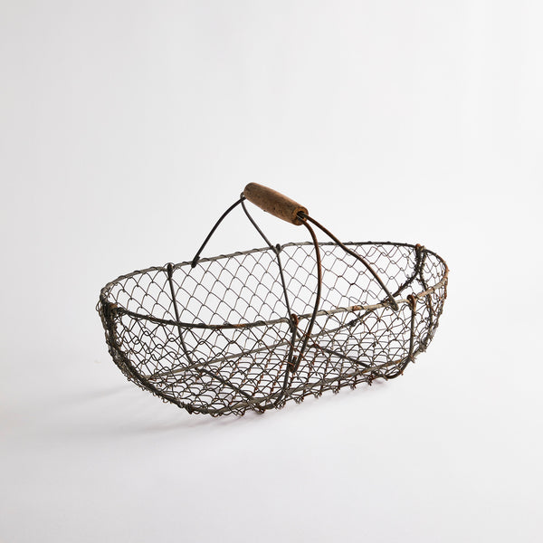 Grey wire basket with wooden handle.