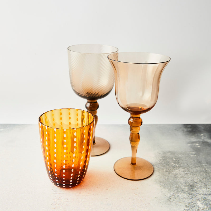 Mixed amber and white dotted tumbler and wine glasses.