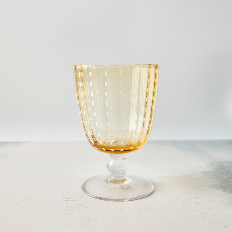 Clear amber and white dotted wine glass.
