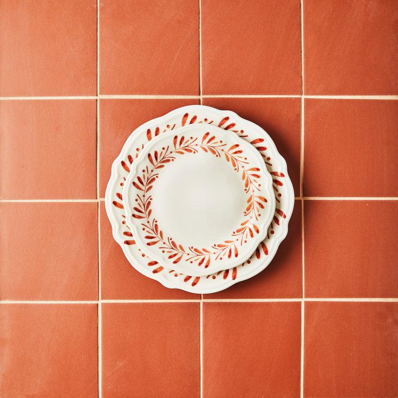 White plate with autumn garland design plates on orange tiled background.