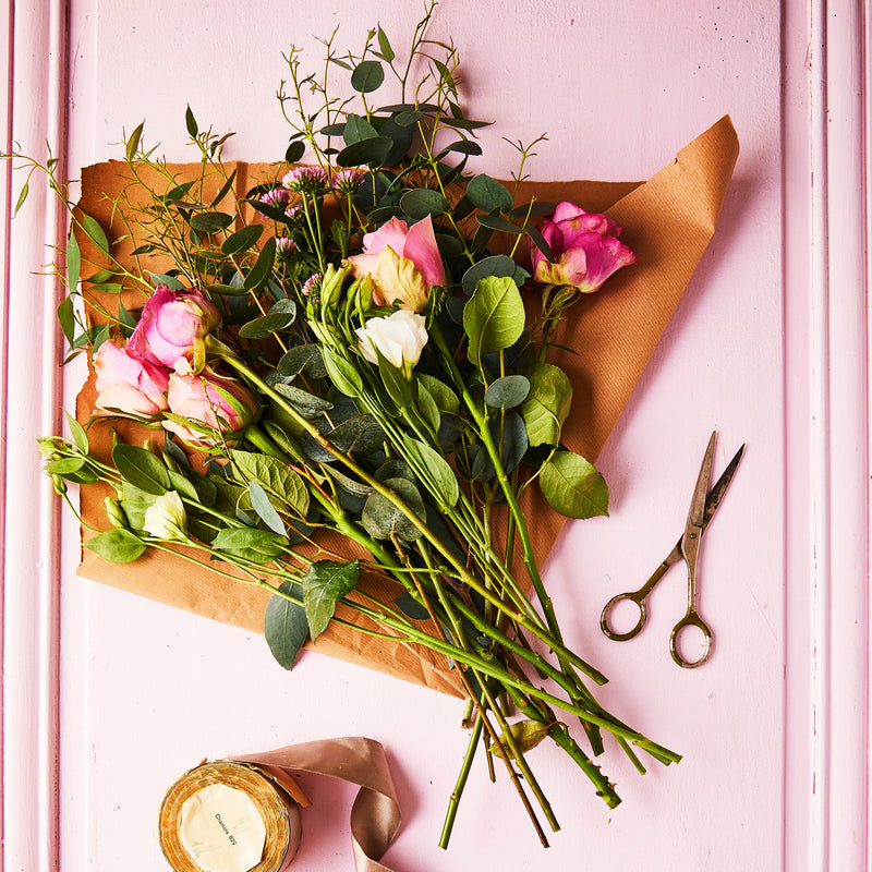 Top view of bouquet of flowers on pink door.