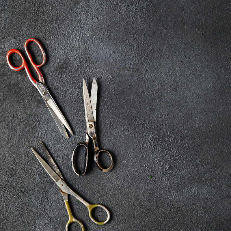 Top view of three scissors on Black Cloud Background.