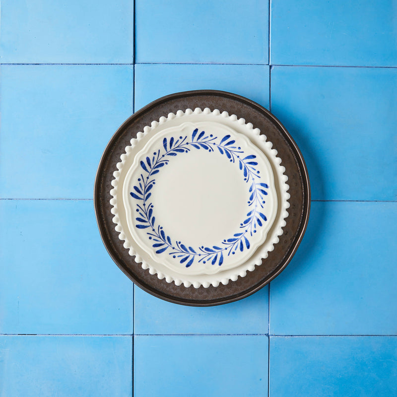 Dark brown, white and white with garland mixed plate set on blue tile background.