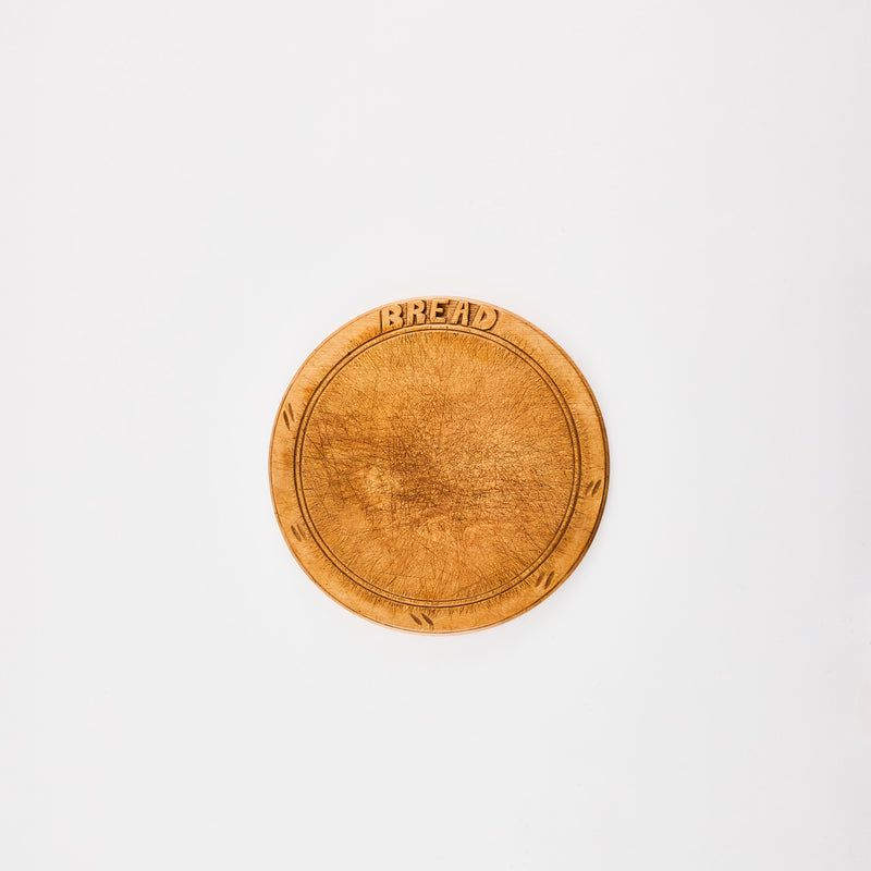 Circular wooden board with text, "bread".