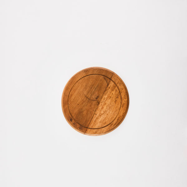 Circular dark wooden board.