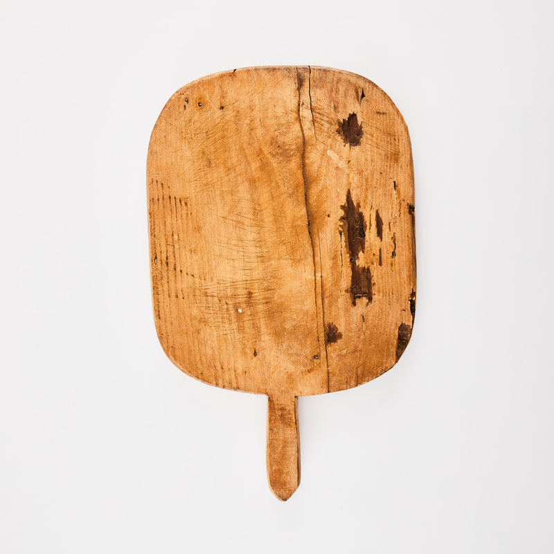 Worn wooden board with handle.