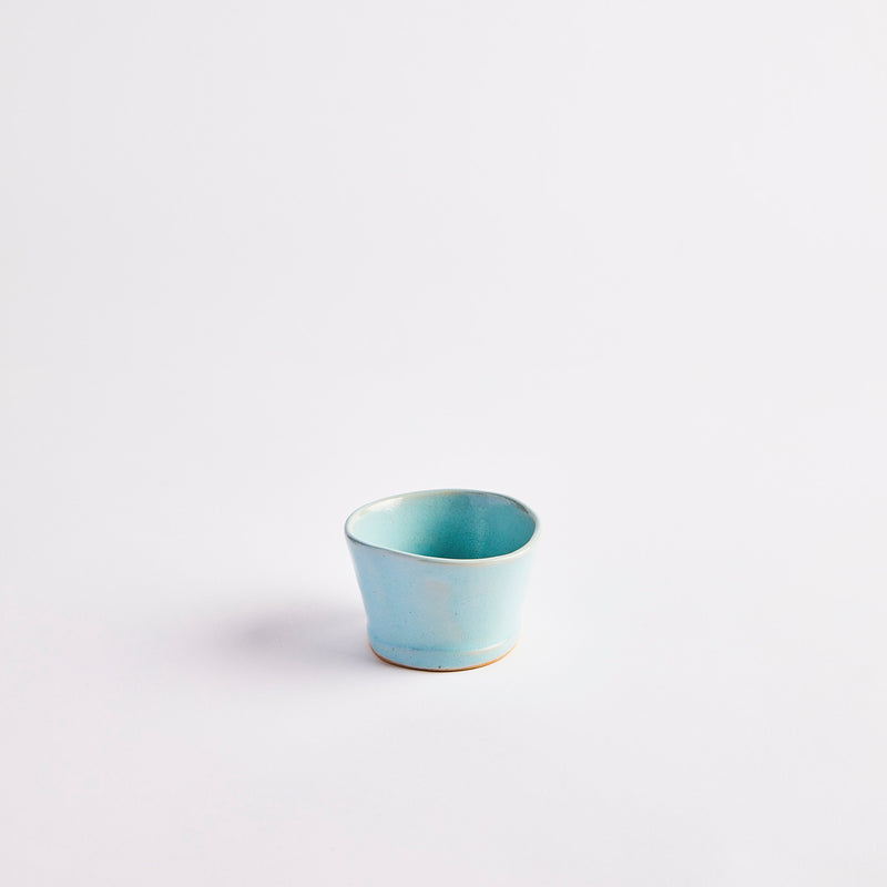Small turquoise ceramic bowl with shiny finish.