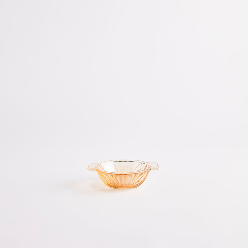 Vintage style small peach coloured clear glass bowl with wave edge detailing.