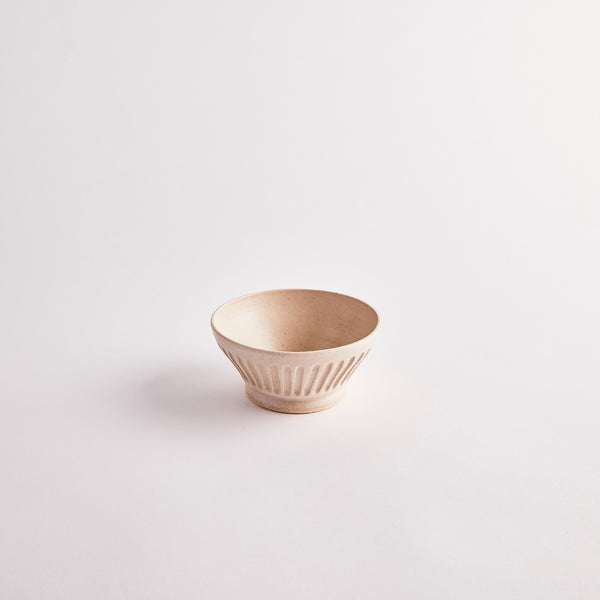 Cream bowl with lined embossed design on the sides.