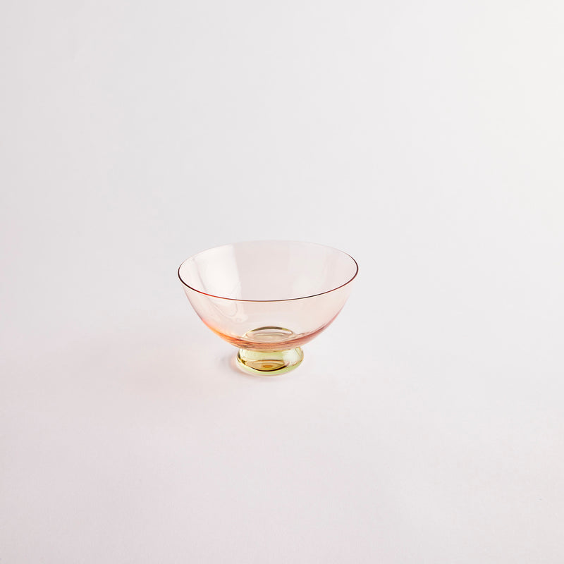 Orange glass bowl with green base.