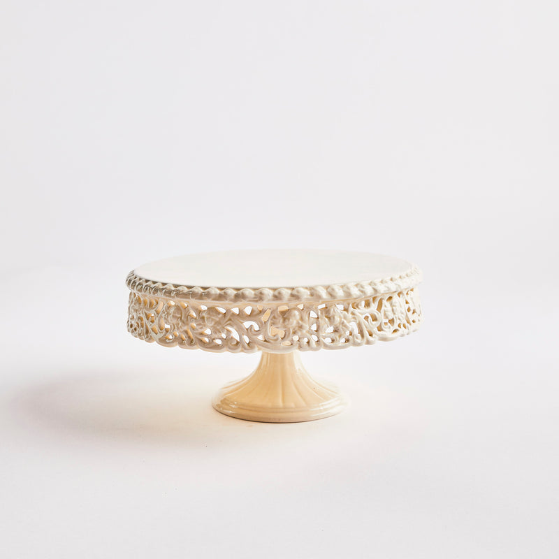 Cream cake stand with lace design edges.