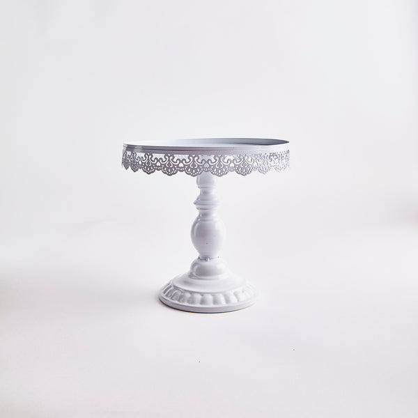White cake stand with decorative edges.