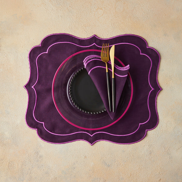 Top view of table setting with purple napkin and place back on beige background.