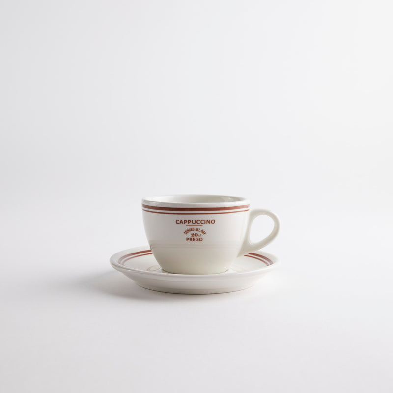 White with red edges coffee cup on saucer with "cappuccino served all day 20 cl prego" text on cup.
