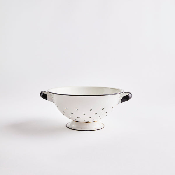 White colander with black edges and handles.