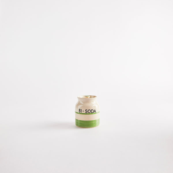 Cream with green line design with text, "bi-soda" container.