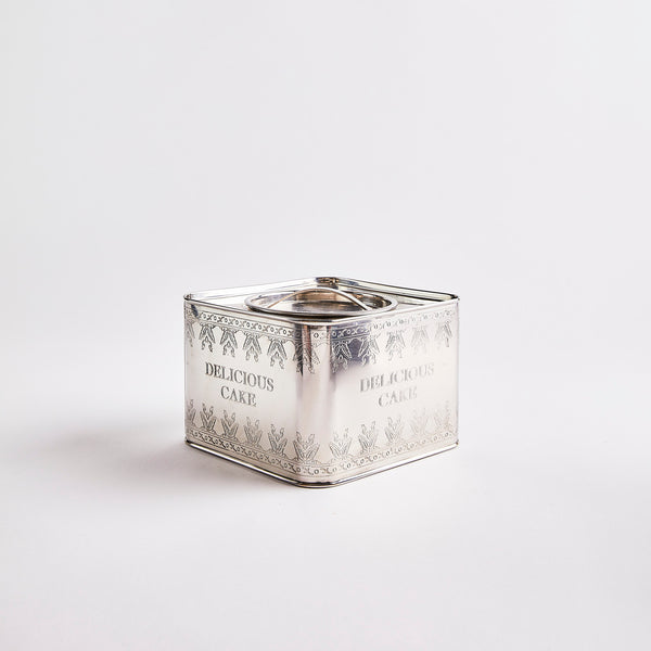 Silver container with delicious cake text. 