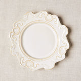 White baroque style plate on beige tablecloth.