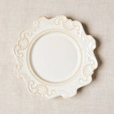White baroque style plate on beige tablecloth.