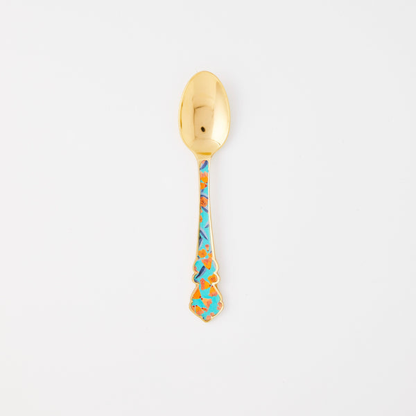 Gold spoon with green floral handle. 