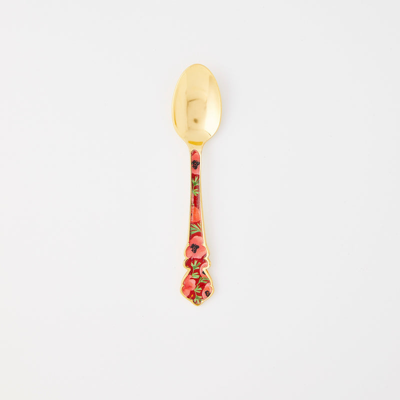 Gold spoon with red floral handle. 