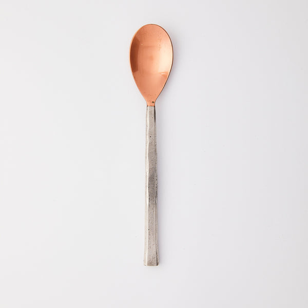 Bronze with silver handle spoon.