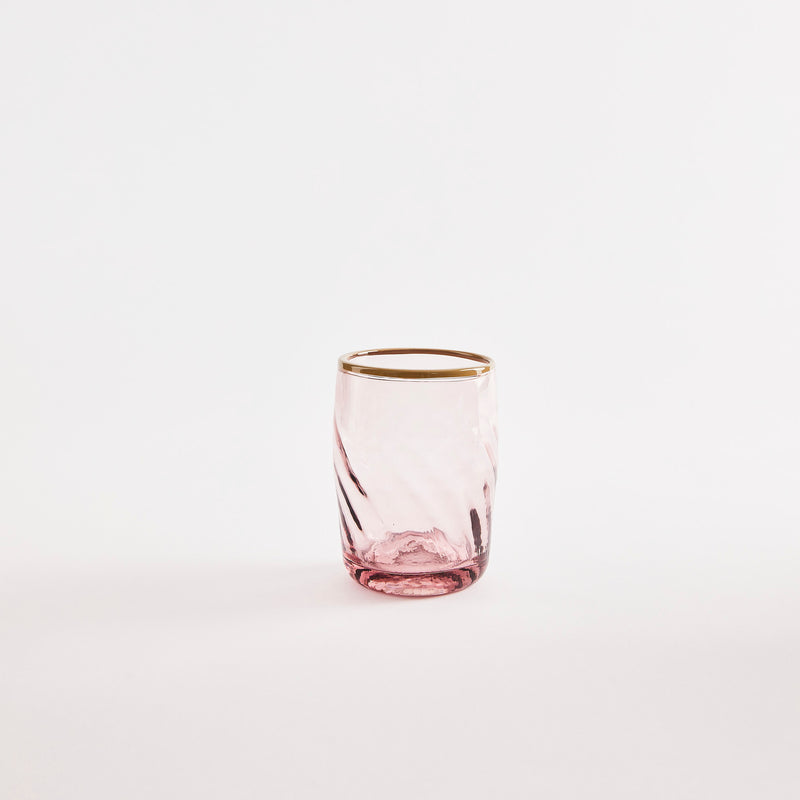 Pink glass tumbler with gold rim.
