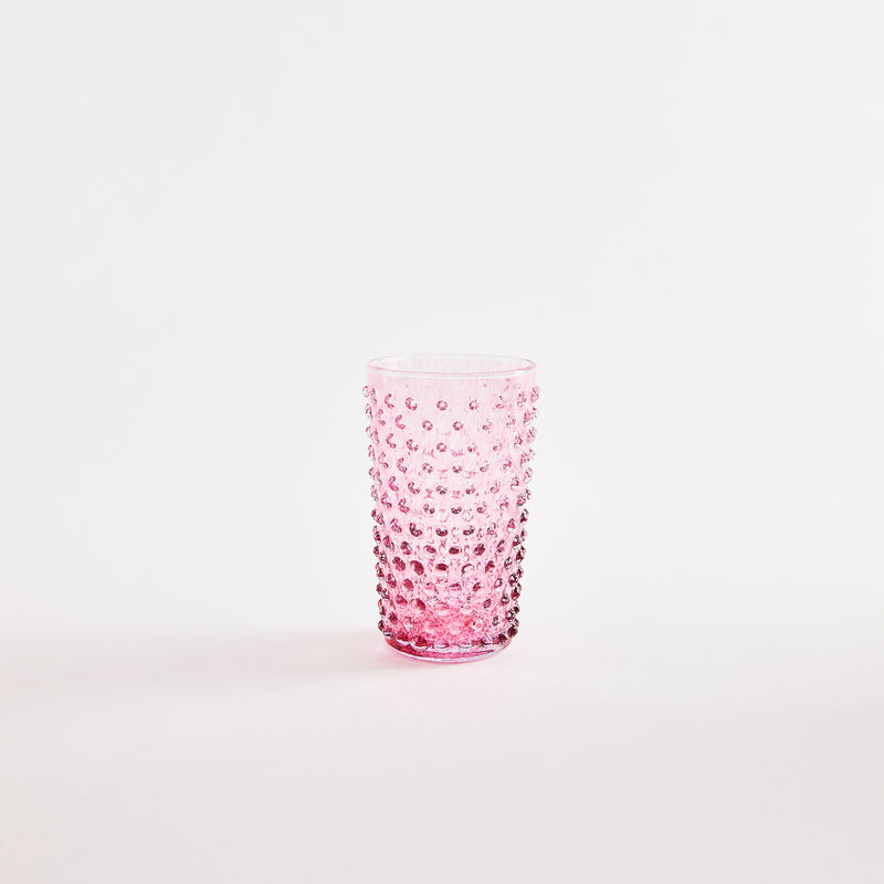Pink glass tumbler with bubbled embossed design.