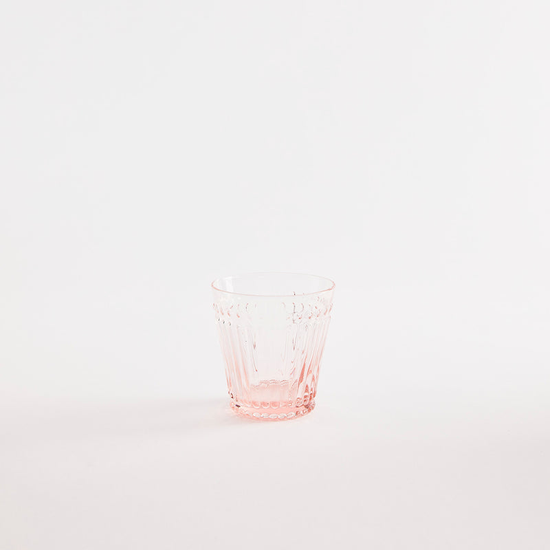 Pink glass tumbler with embossed design.