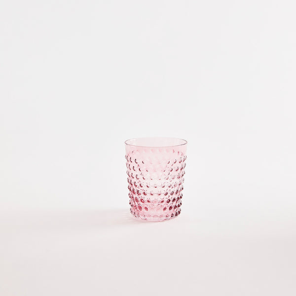 Pink glass tumbler with bubble embossed design.
