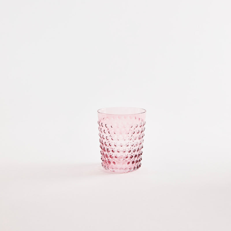 Pink glass tumbler with bubble embossed design.