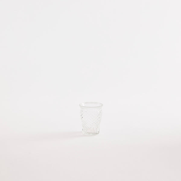 Clear glass tumbler with embossed design.
