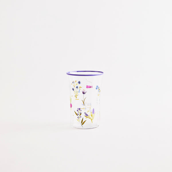 Mulitcolour floral design glass tumbler with purple rim.
