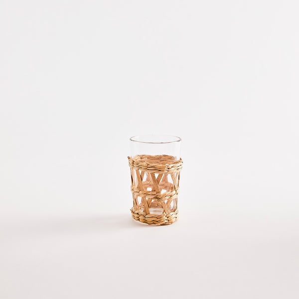 Clear glass tumbler with weave sleeve.
