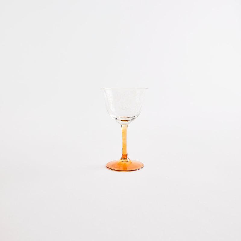 Clear glass with orange stem.
