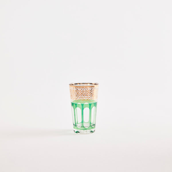 Green glass tumbler with gold design.