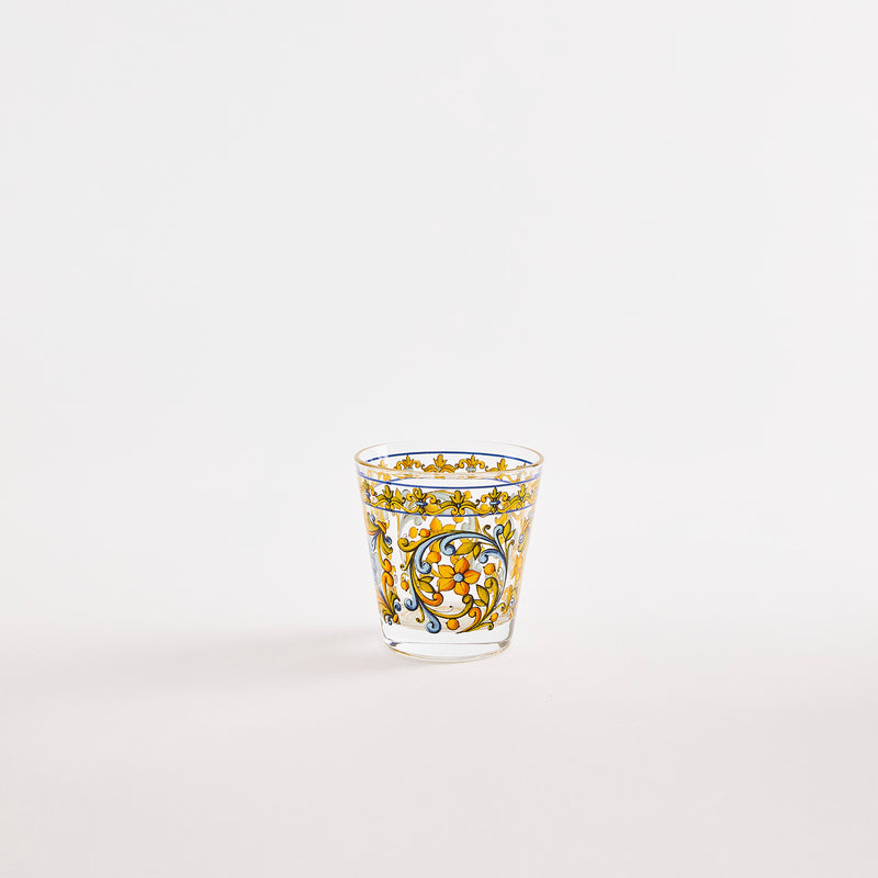 Clear glass tumbler with multicoloured decorative pattern.