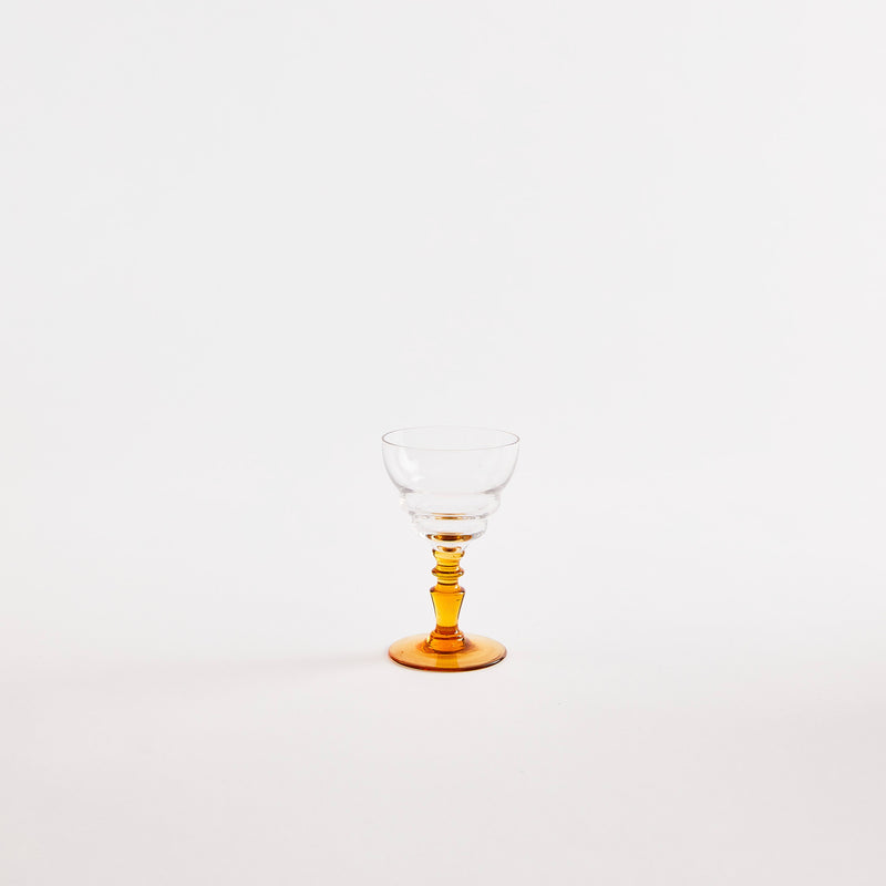 Clear wine glass with yellow base.