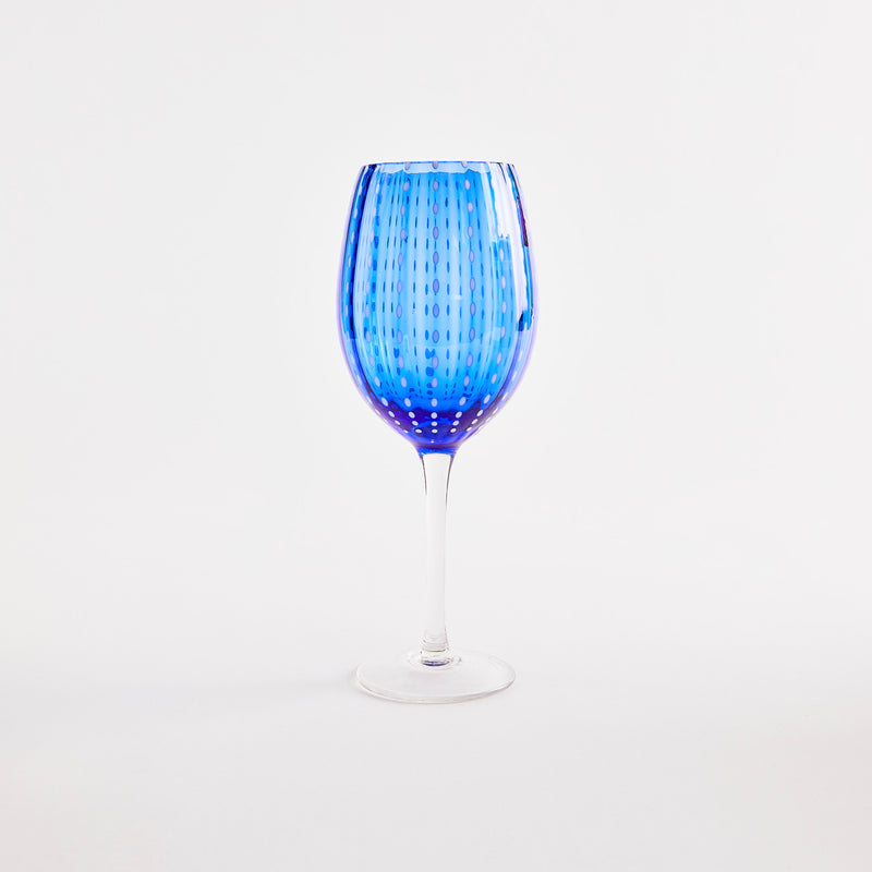 Blue with white dotted design wine glass with clear stem.