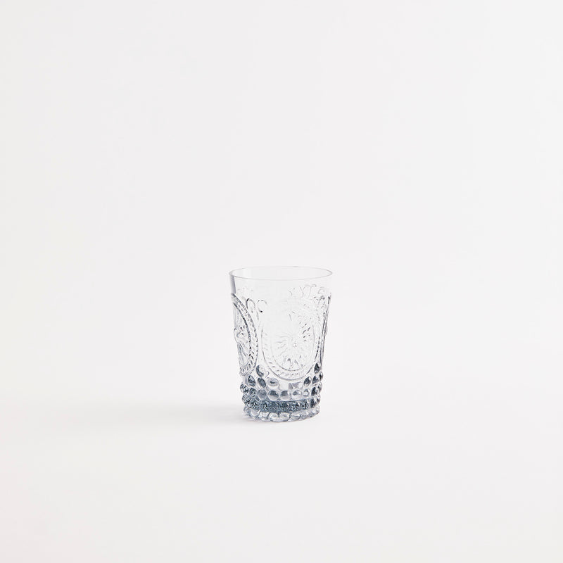 Grey glass tumbler with embossed design.