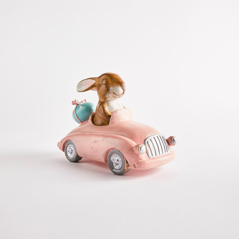 Brown easter bunny in pink car.