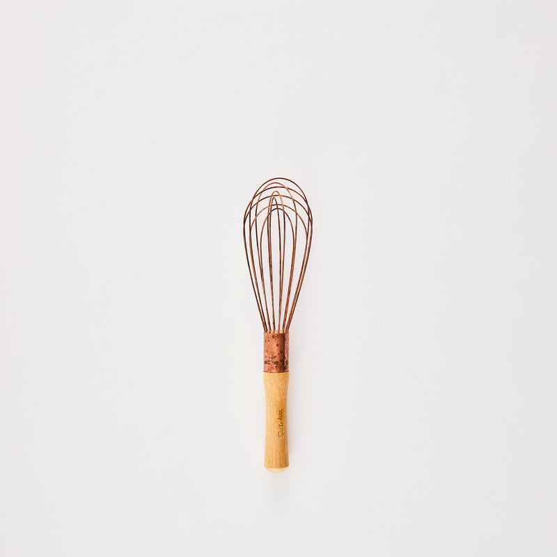 Copper whisk with wooden handle.