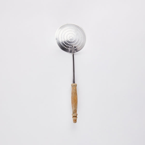 Large slotted silver kitchen spoon with wooden handle.